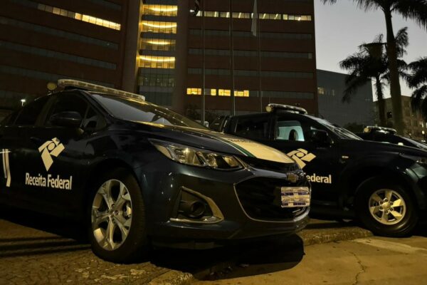 Agentes da Receita Federal e Polícia Federal em ação de busca e apreensão durante uma operação contra fraudes fiscais e criminais.