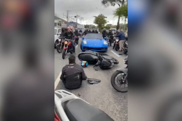 Influenciador MK Bernardino é detido por populares após atropelar motociclista em São Paulo Veículo de luxo da marca Porsche em uma avenida movimentada, ilustrando o tipo de carro envolvido no acidente.