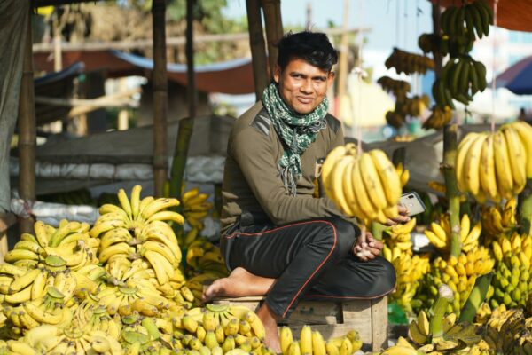 Microinfluenciadores: Ascensão e Impacto no Consumo Local A smiling vendor selling bananas at an outdoor market in Khulna, Bangladesh.
