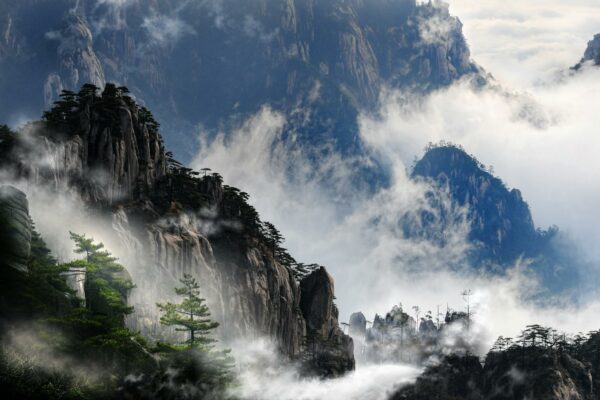 Crise Hídrica Global Ameaça Segurança Alimentar e Migrações Misty mountain peaks of Huangshan, China enveloped in fog, creating a serene and dramatic landscape.