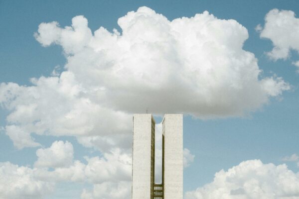 Cresce Pressão por Transparência em Fundos de Pensão Estatais View of the National Congress in Brasília with impressive cloud formations in the sky.