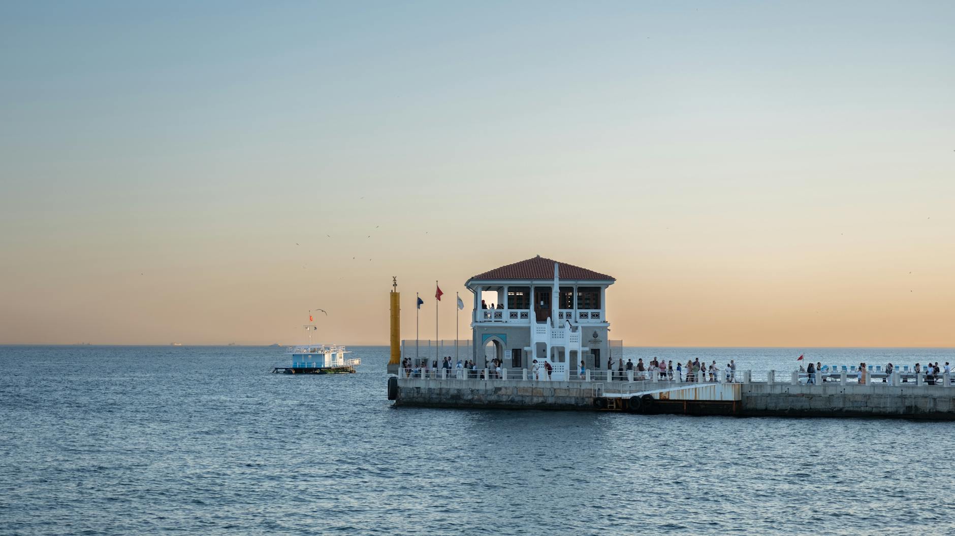 Stunning sunset view of Moda Pier in Istanbul, capturing serene sea and ferry.