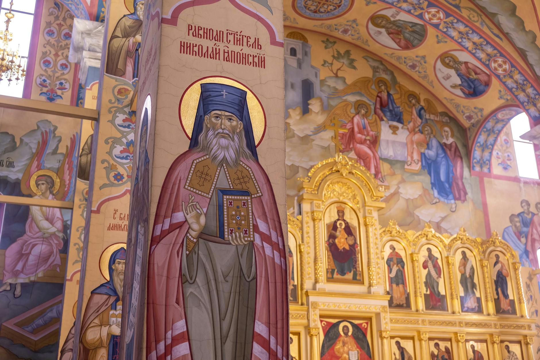 Richly decorated Orthodox church interior showcasing intricate frescoes and religious icons.
