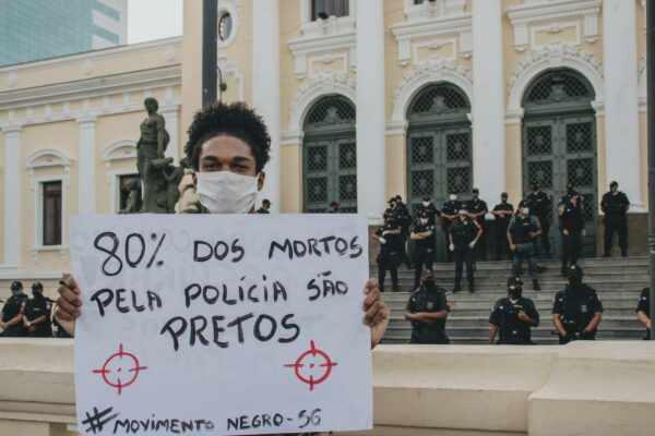 A protest in Rio de Janeiro advocating for Black Lives Matter with a demonstrator holding a sign.