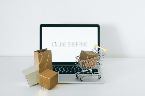TJSP agiliza divórcios com plataforma online inédita Laptop displaying online shopping with boxes and cart, representing ecommerce.