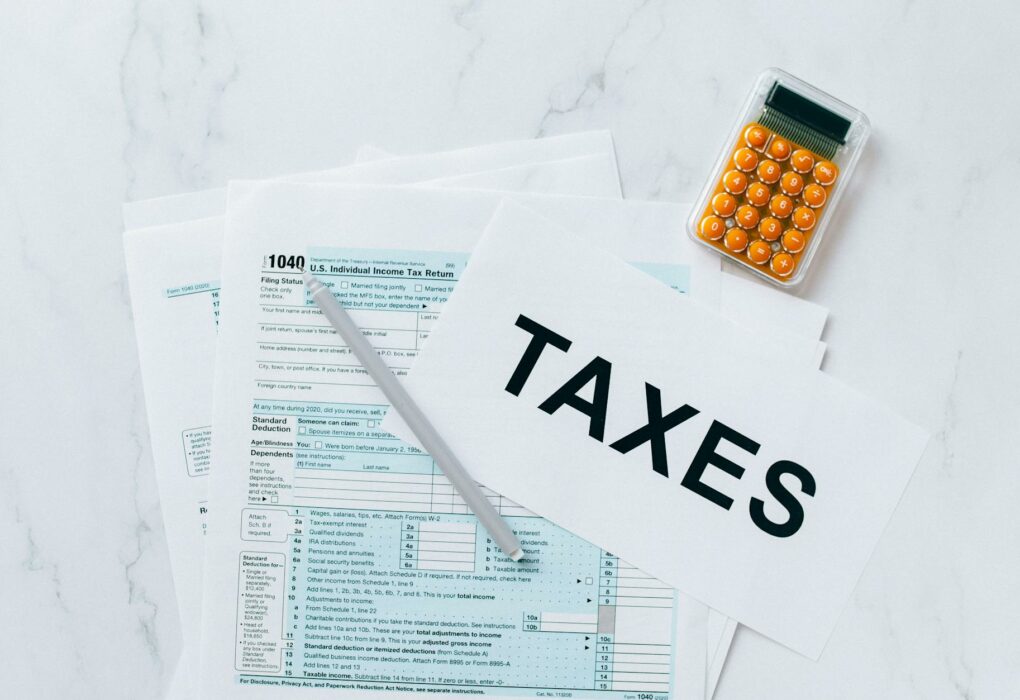 Top view of tax forms, a calculator, and pen for tax preparation.