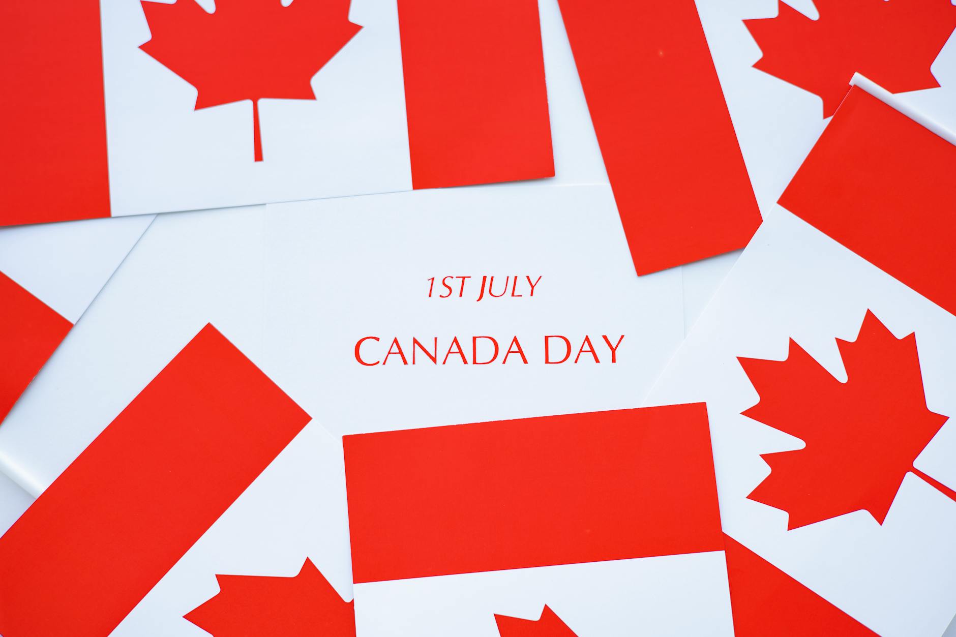 Vibrant Canada Day celebration featuring Canadian flags and maple leaves in red and white.