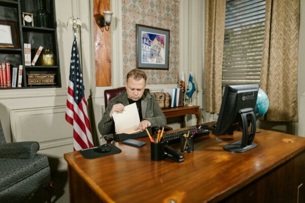 Câmara aprova urgência para projeto que limita aborto legal A lawyer in an office reviewing legal documents at a desk with an American flag nearby.