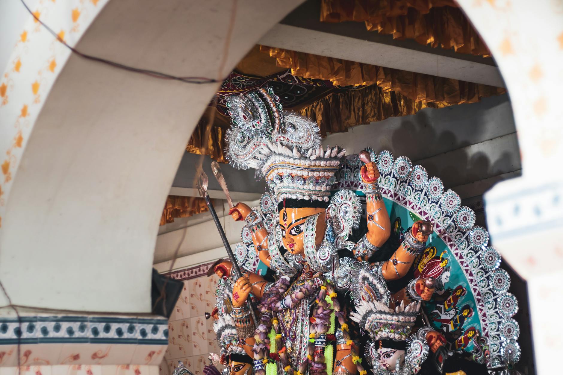 Colorful Durga idol adorned with ornaments at a Hindu festival celebration.