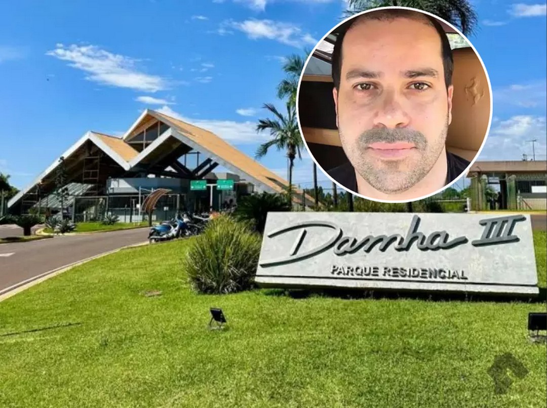 Fachada de um condomínio residencial de luxo com portaria, em dia ensolarado.