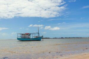 Aumento de Denúncias de Violência Obstétrica em SP Acende Alerta Serene view of a fishing boat on Morro de São Paulo beach in Bahia, Brazil under a clear blue sky.