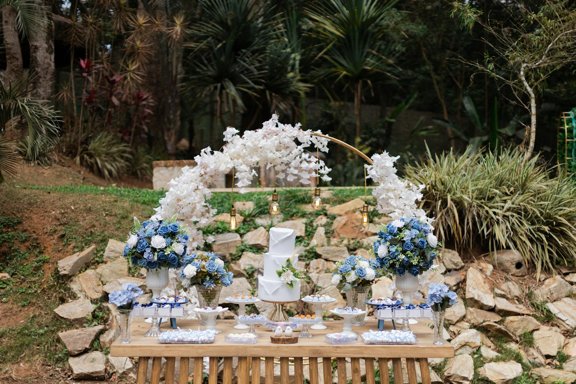 Outdoor dessert table with blue and white floral decor set in São Paulo, perfect for weddings or celebrations.