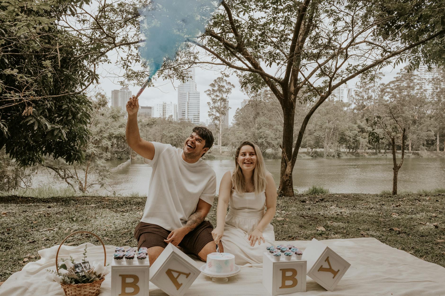 Happy couple enjoying a gender reveal picnic at Ibirapuera Park in São Paulo, Brazil.