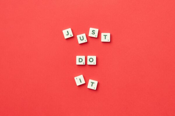 STF Valida Acordo Coletivo Sobre Jornada de Trabalho Motivational phrase 'Just Do It' spelled with Scrabble letters on a red background.