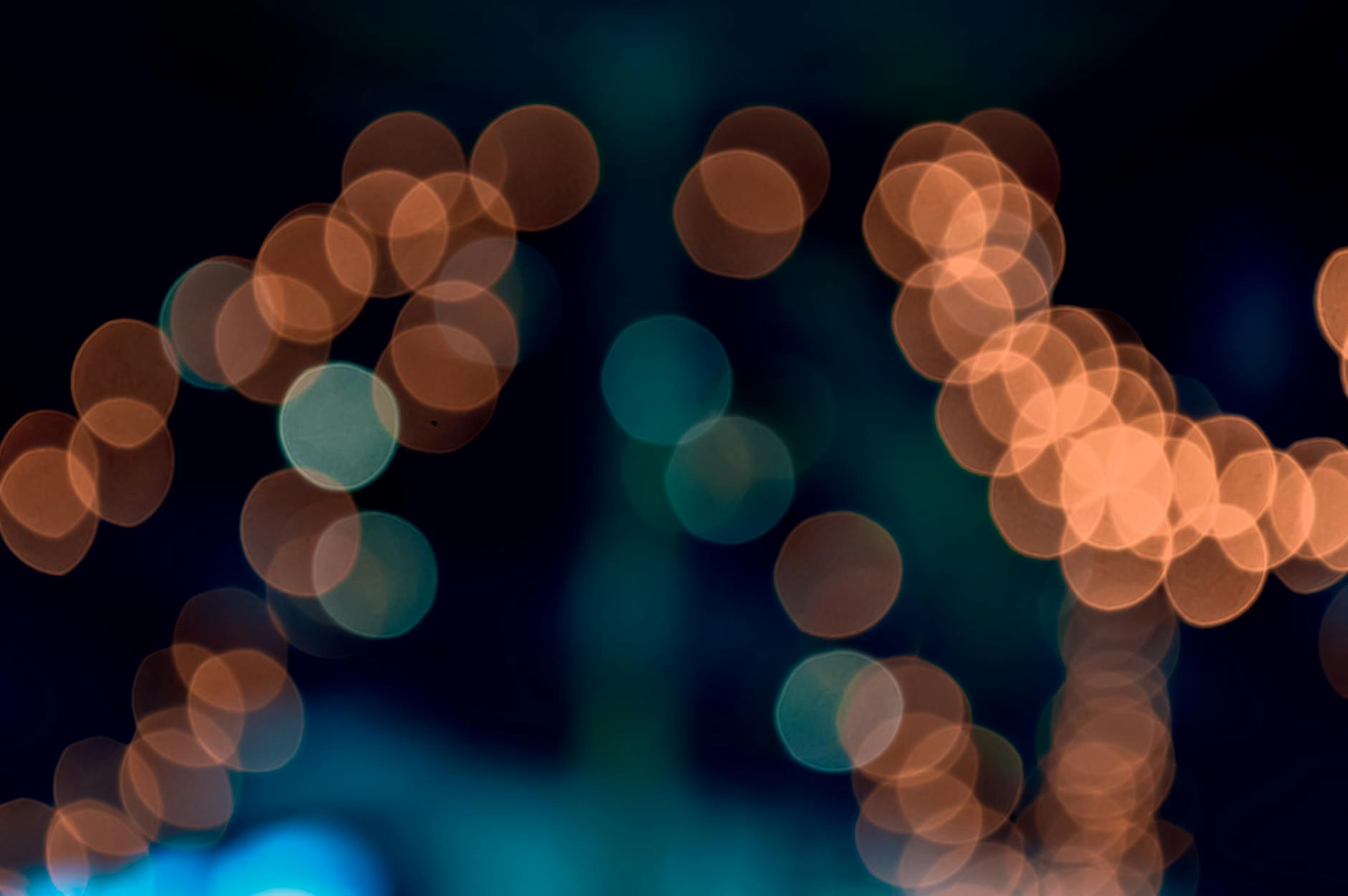 Abstract bokeh light patterns in vibrant orange and teal hues create an artistic effect.