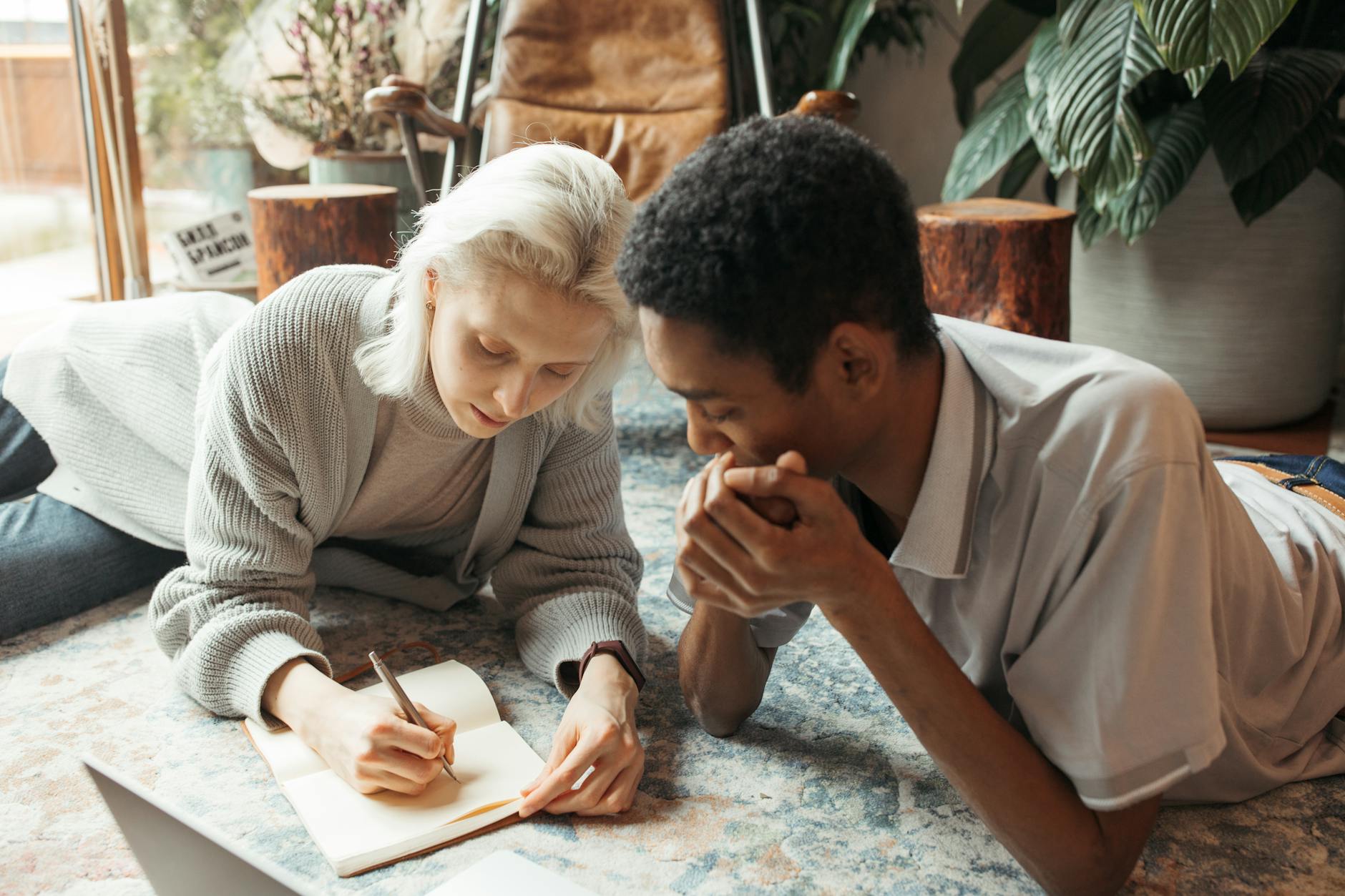 Two colleagues collaborate in a modern indoor workspace, discussing ideas.
