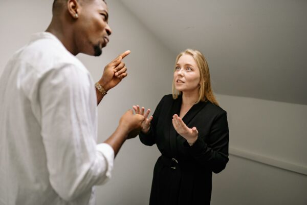 Câmara Debate Reforma do Código de Processo Penal Two business professionals in a heated discussion inside a modern office space.