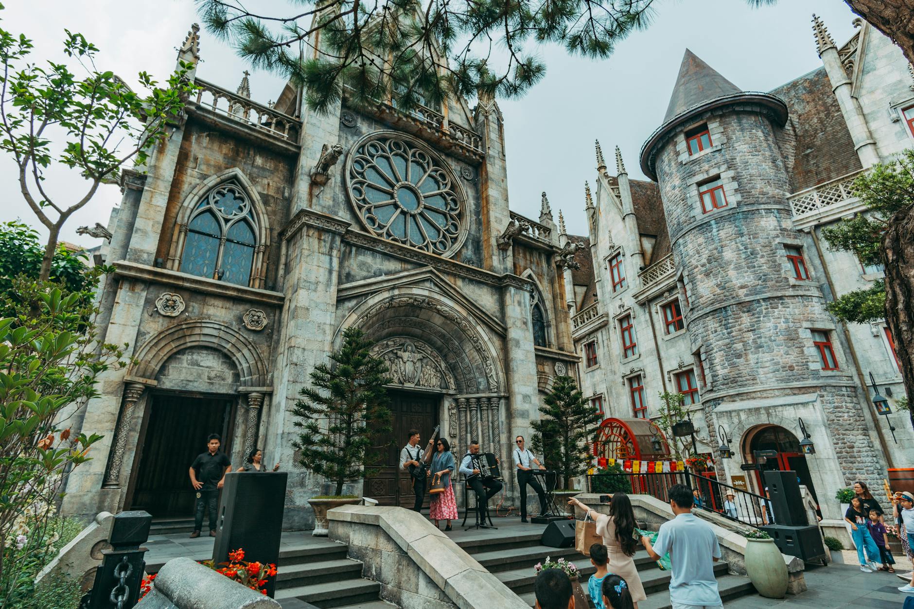 A vibrant scene of street performers and tourists in front of majestic Gothic architecture.