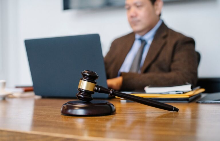 Martelo da justiça sobre mesa de escritório com elementos digitais e institucionais